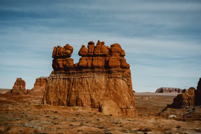 A red sandstone formation under a pale blue desert sky, in Agfa Vista 400