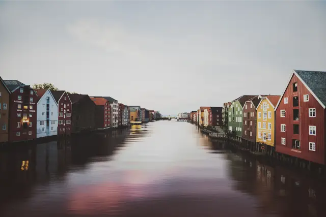 Painted wooden warehouses along a calm river in Trondheim, in DSTY G 800