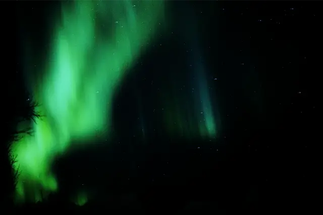 Green northern lights across a night sky, in VNTG 800