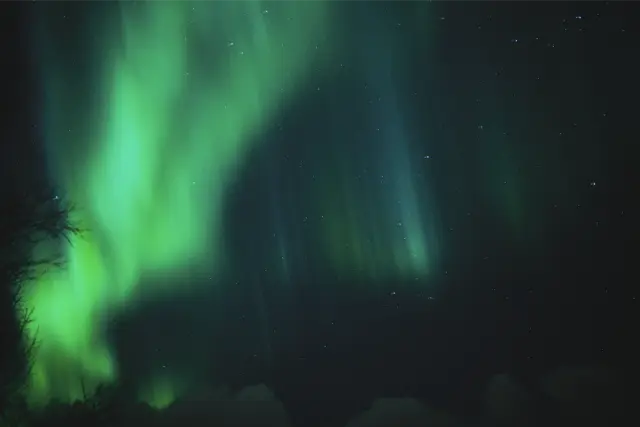 Green northern lights across a night sky, in Kodak Portra 800