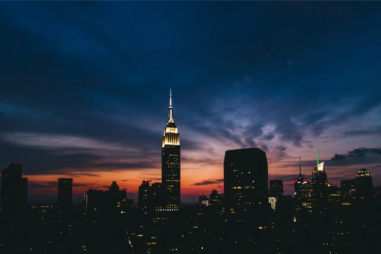 The Empire State Building against a deep blue and orange dusk sky, unedited