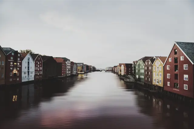 Painted wooden warehouses along a calm river in Trondheim, in SVAL C 100